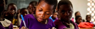 Un jeune garçon prend des notes en classe dans une école au Malawi.