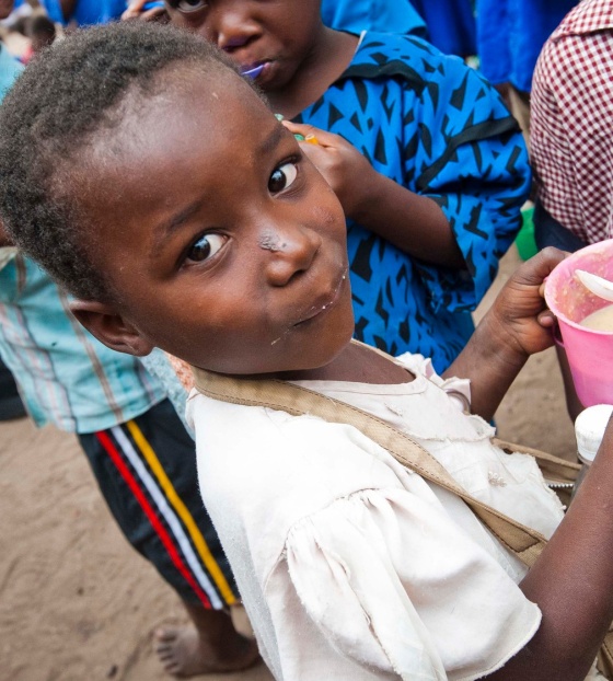Un enfant reçoit de la nourriture de la part de Mary's Meals à l'école.