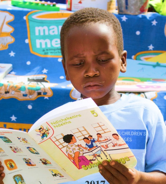 Un jeune garçon lit un livre.
