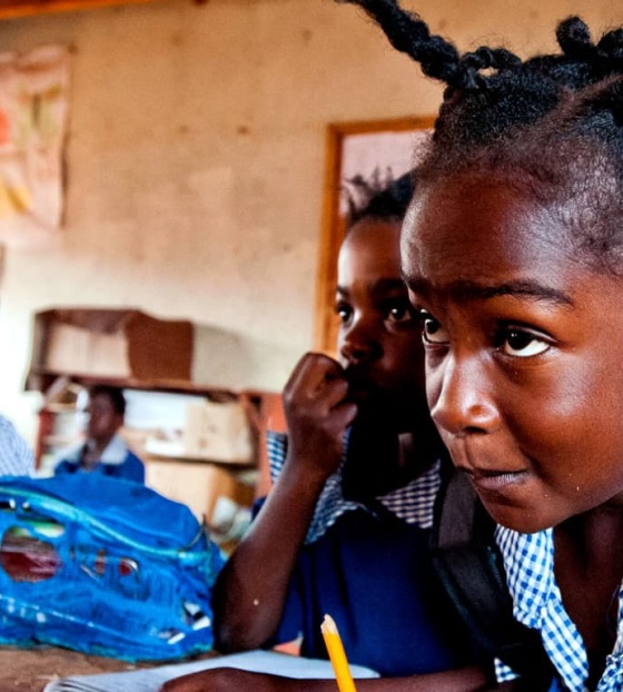 Une jeune fille concentrée alors qu'elle prend des notes en classe.