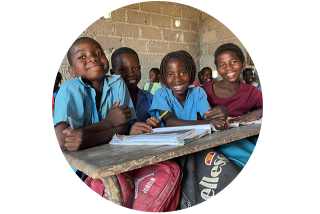Image circulaire d'enfants souriants dans une salle de classe.