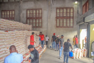 Workers and volunteers sorting food in a warehouse.